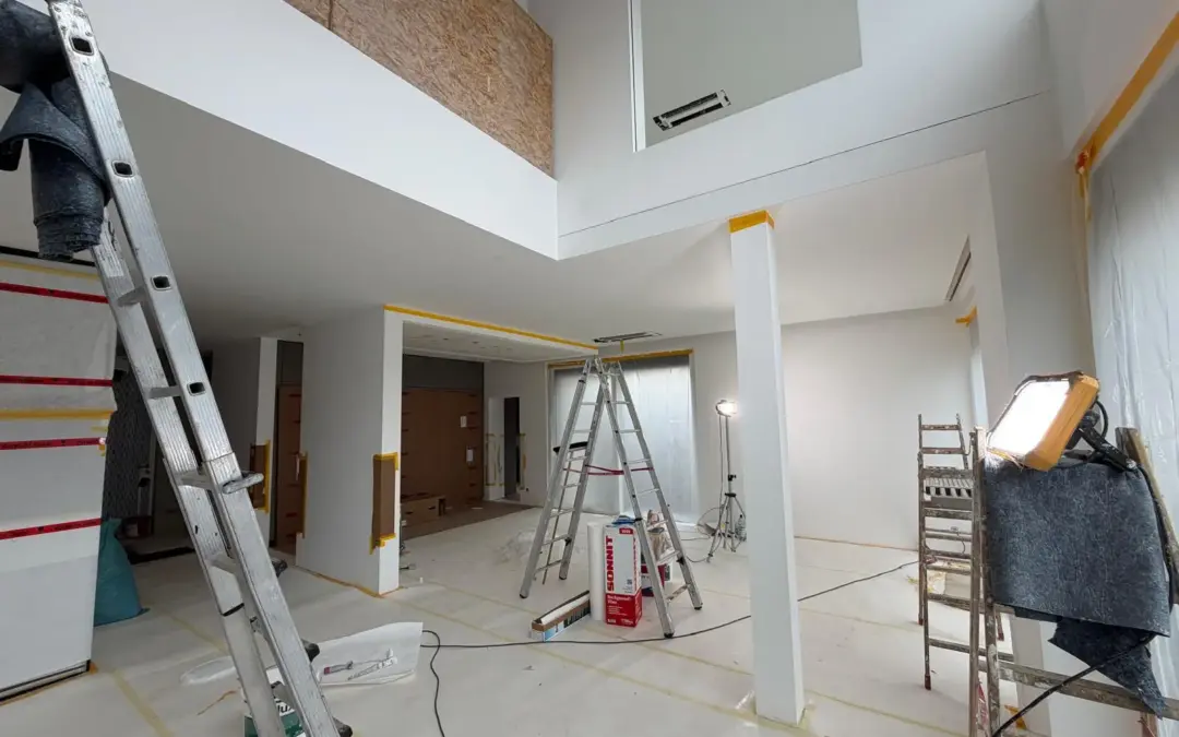 Vorbereitung hochwertiger Malerarbeiten: gespachtelte Wände und Decken im Q3-Standard, abgedeckter Boden und Beleuchtung für Superlux-Finish in einem modernen Neubau.