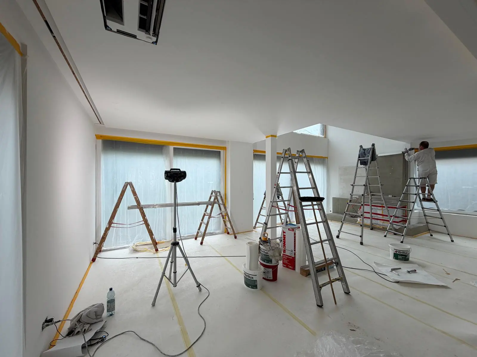 Innenausbau mit Q3-Spachtelung und Vliesarbeiten: Malerarbeiten unter professioneller Beleuchtung im modernen Wohnraum.