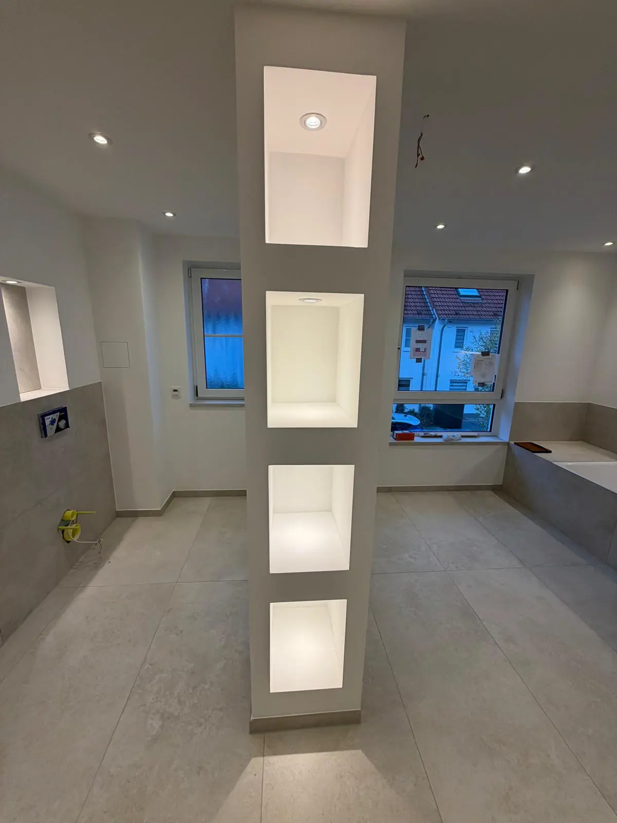 Badsanierung mit beleuchteter Regalwand – Sedashine Seidenmatt und präzise Spachtelarbeiten von farbDESIGN und WERKstatt Korschenbroich.