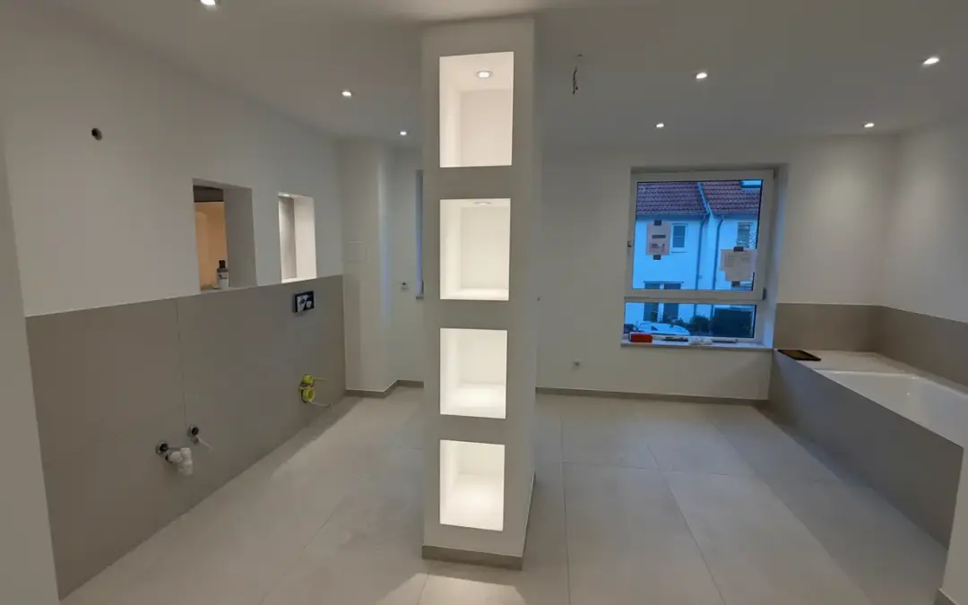 Gesamtansicht des modern gestalteten Badezimmers mit beleuchteter Regalwand, Sedashine-Wänden und präzisen Fliesenarbeiten von farbDESIGN und WERKstatt aus Korschenbroich.